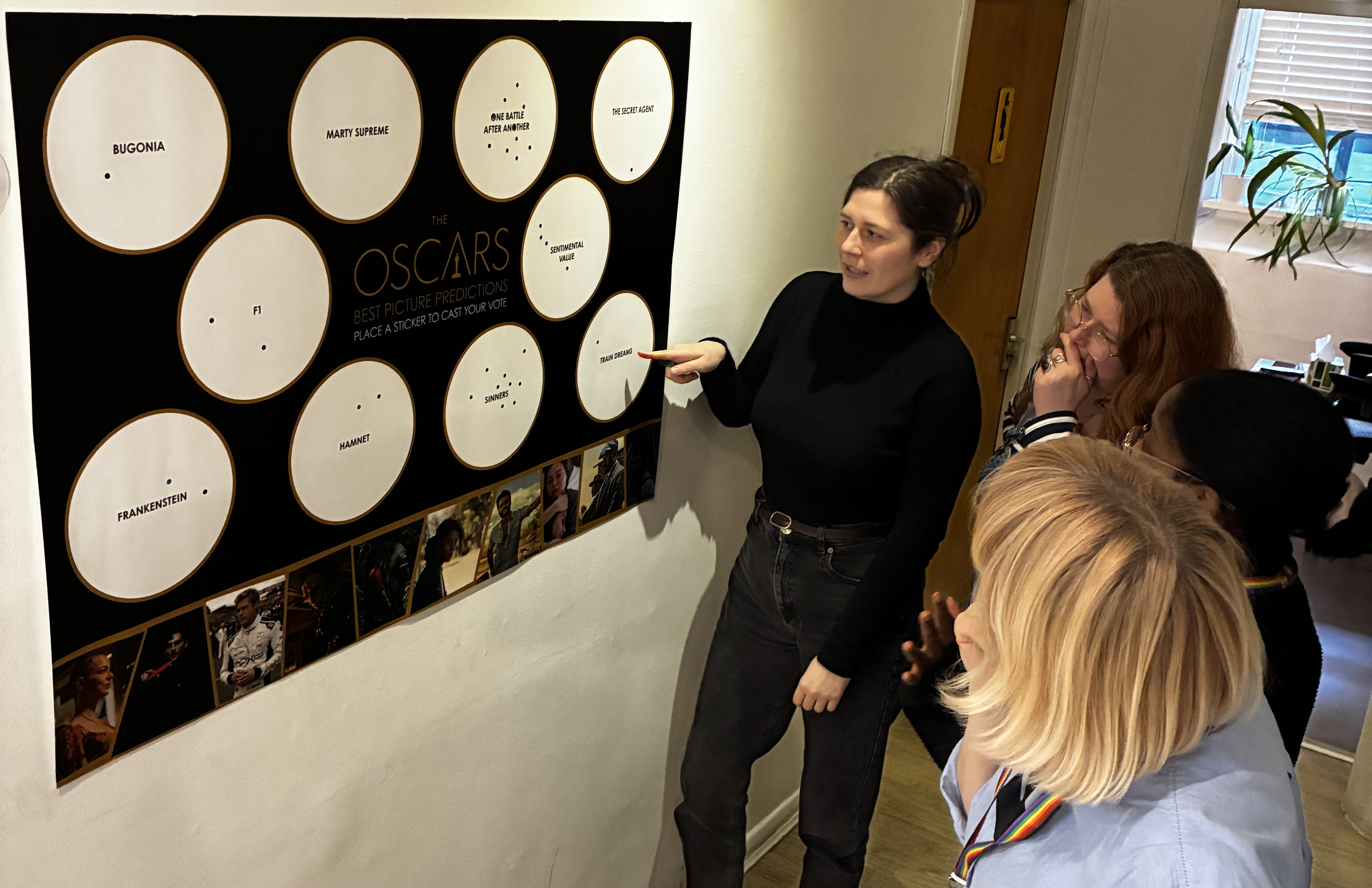 Four LFA staff members looking at Oscar board